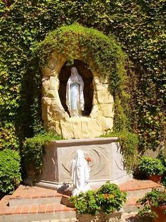 the statue is surrounded by greenery and stone