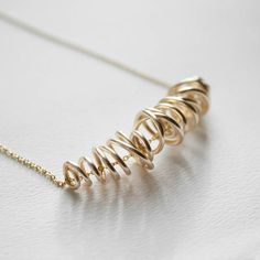 This hand formed gold wire necklace is truly one of a kind. Each one is free formed out of gold plated wire to be both delicate and sophisticated. This necklace can be made out of gold plated or sterling silver wire and chain. Approx I8" in length, Gold wire swirl approx. 1.5" long. Elegant Gold Swirl Necklace, Minimalist Gold Spiral Jewelry, Sterling Silver Yellow Gold Wire Wrapped Necklaces, Minimalist Yellow Gold Wire Wrapped Necklace, Gold Spiral Necklaces For Jewelry Making, Delicate Gold Wire Wrapped Necklaces, Unique Yellow Gold Wire Wrapped Necklaces, Delicate Gold Wire Wrapped Necklace, Unique Gold Spiral Necklace