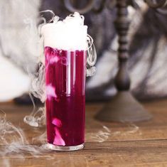 a glass filled with liquid sitting on top of a wooden table