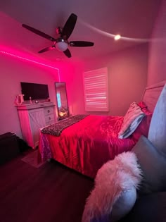 a bed room with a neatly made bed and a pink light