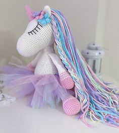 a crocheted unicorn doll sitting on top of a table