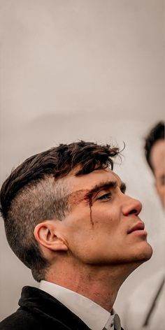 a man in a suit and tie looking off into the distance with his head tilted back