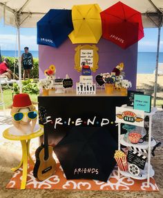 a table topped with an umbrella next to a beach covered in signs and other items