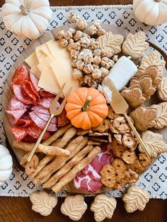 an assortment of cheeses, crackers, and meats on a platter