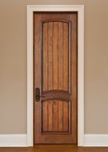 a wooden door in the corner of a room