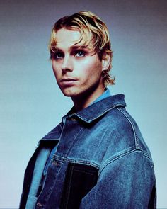 a man with blonde hair wearing a jean jacket