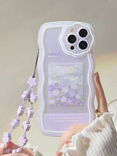 a woman holding up a cell phone case with flowers on it