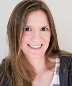 a woman with long brown hair smiling at the camera