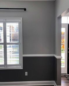 an empty room with gray walls and white shutters