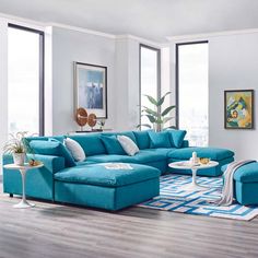 a living room with blue couches and white rugs in front of large windows