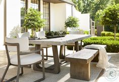 an outdoor dining table with benches and potted plants