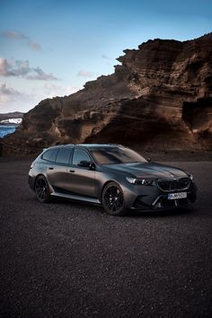 a grey car parked in front of some rocks