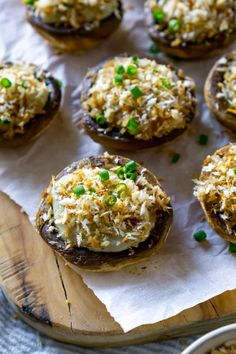 baked mushrooms with cheese and green onions on a cutting board