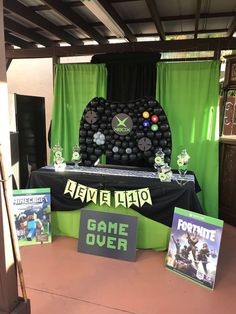 a table with video game memorabilia and games on it in front of a green curtain