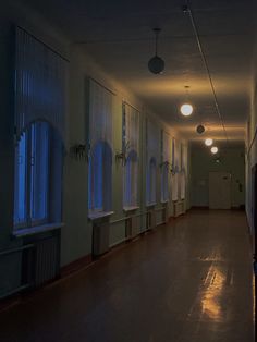 an empty hallway with several windows and lights