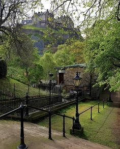 an old building with a castle on the top of it's hill in the background