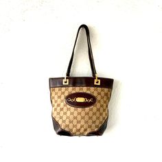 "S p e c i f i c s . . . Label: Gucci Measurements: 7.5\"L x 4\"W x 9.5\"H Color: Beige // Brown // Gold Material: Leather // Canvas // Goldtone Metal Condition: Overall in Amazing Vintage Condition" Gucci Luxury Monogram Canvas Satchel, Travel Bag With Brass Hardware And Monogram Canvas, Luxury Bag In Monogram Canvas With Brass Hardware, Vintage Leather Bags With Horsebit Detail, Vintage Shoulder Bag With Horsebit Detail, Vintage Shoulder Bag With Horsebit Detail For Everyday, Formal Monogram Canvas Bag With Horsebit Detail, Luxury Brown Bags With Horsebit Detail, Vintage Rectangular Shoulder Bag With Horsebit Detail