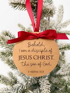 a wooden ornament hanging from a christmas tree with a red ribbon on it