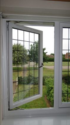 an open window in a room with grass and trees