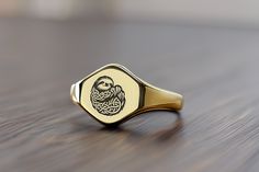 Embrace the laid-back charm of the sloth with our Custom Gold Hexagon Signet Ring, beautifully engraved with a detailed sloth design. This ring celebrates the slow-moving and peaceful nature of sloths, making it a delightful addition to the jewelry collection of any animal lover or anyone who appreciates life's quieter moments. Crafted from high-quality gold, the hexagon shape offers a modern twist on a classic piece, perfect for those who value unique and meaningful accessories. Whether as a gi Sloth Ring, Dna Jewelry, Hexagonal Ring, Fancy Gifts, Unique Handmade Jewelry, Hexagon Shape, Animal Jewelry, Signet Ring, Types Of Metal