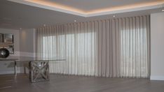 an empty living room with white curtains and wood floors