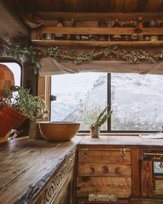 a kitchen with wooden counter tops and an open window overlooking the snow covered mountain range