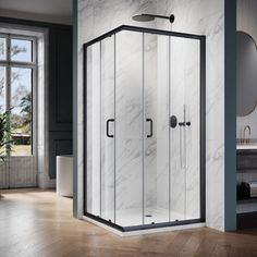 a corner shower stall in a bathroom with marble walls and flooring next to a window