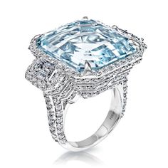 a ring with an aqua blue topazte surrounded by white diamonds and halos