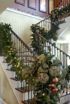 a staircase decorated with christmas decorations and greenery on the bannister railings