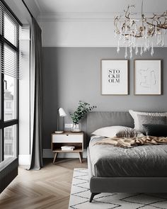 a bedroom with gray walls and wooden flooring, a chandelier hanging from the ceiling