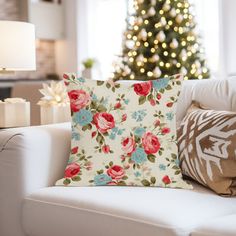 a living room with a christmas tree in the background and flowers on the pillow cover