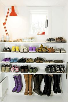 there are many pairs of shoes on the shelves in this room, all lined up