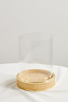 a glass and gold plate on a white table