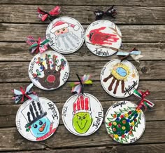 six handprinted christmas ornament ornaments on a wooden table with ribbons and bows