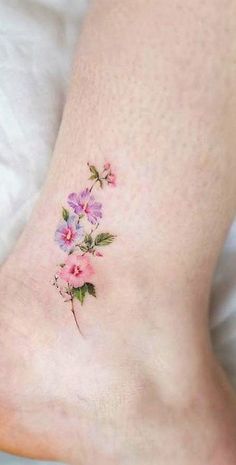 a woman's foot with flowers on it and the bottom part of her leg