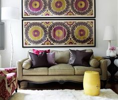 a living room filled with furniture and pillows on top of a white carpeted floor