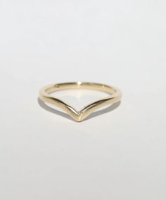 a gold ring with an irregular shaped design on the front and side, against a white background