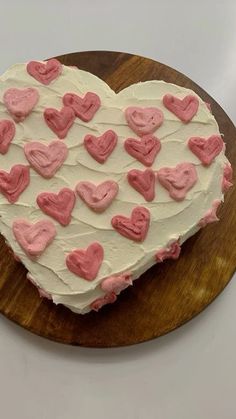 a heart shaped cake sitting on top of a wooden cutting board