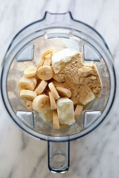 bananas and other ingredients in a blender on a marble counter