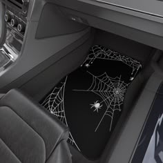 the interior of a car with a spider web on it's front door mat