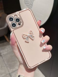 a woman holding an iphone case with a bow on it