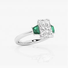 an emerald and white gold ring with three stone accents on the band, set in 18k white gold