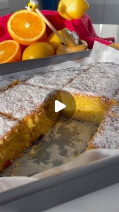 an orange cake sitting on top of a pan next to some sliced up oranges