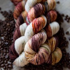 several skeins of yarn sitting on top of coffee beans