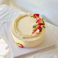 a white cake with strawberries on top