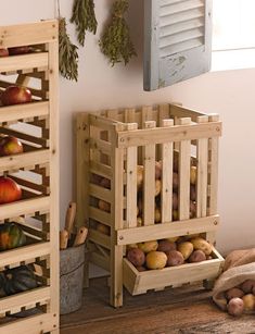 two wooden crates filled with fruits and vegetables on top of a wood floor next to a window