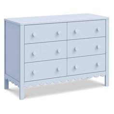 a white dresser with four drawers and two knobs on the front, and one drawer at the bottom