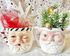 two ceramic mugs with christmas decorations on them and one has a santa claus face