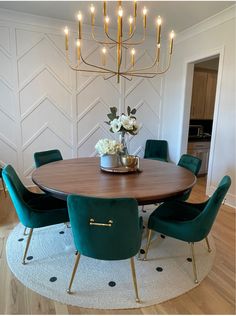 a dining room table with green chairs and a chandelier