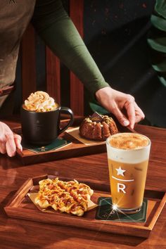 two people are sitting at a table with food and drinks in front of them on trays